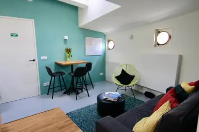 a living room with a couch and a table at Sailor Suite Coaster Mado in Amsterdam