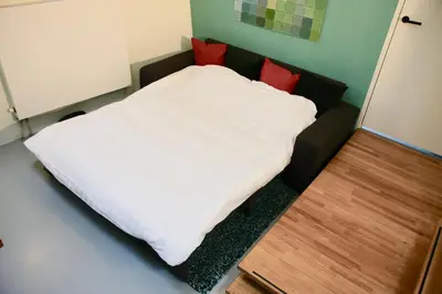 a bed with white sheets and red pillows in a room at Sailor Suite Coaster Mado in Amsterdam