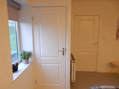 a white door in a room with a window at UNESCO de Beemster, vakantiewoning in Noordbeemster