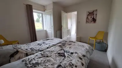 a bedroom with a bed and two chairs and a window at UNESCO de Beemster, vakantiewoning in Noordbeemster