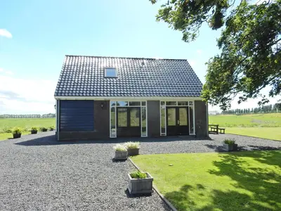 a small house with a pitched roof and a gravel yard at UNESCO de Beemster, vakantiewoning in Noordbeemster