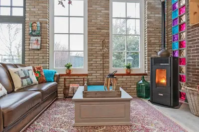 a living room with a couch and a wood stove at Wellness Bed & Breakfast Pergamo in Voorhout