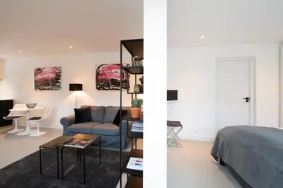 a bedroom and a living room with a bed and a table at Longhouse Studio Zandvoort in Zandvoort