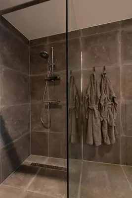 a bathroom with a shower with a glass door at Longhouse Studio Zandvoort in Zandvoort