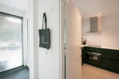 a small kitchen with a black and white kitchen at Longhouse Studio Zandvoort in Zandvoort