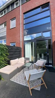a patio with a couch and a table and chairs at Canal Garden Apartment StayWell Amsterdam in Amsterdam