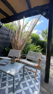 a patio with two chairs and a table and an umbrella at Canal Garden Apartment StayWell Amsterdam in Amsterdam