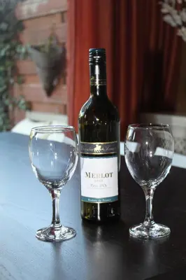 a bottle of wine and two wine glasses on a table at Canal Garden Apartment StayWell Amsterdam in Amsterdam