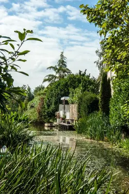 a cabin in the middle of a river at Canal Garden Apartment StayWell Amsterdam in Amsterdam