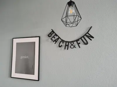 a mirror and a light hanging on a wall with a sign at The BLOOM in Noordwijk aan Zee