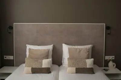 a large bed with white sheets and pillows at The BLOOM in Noordwijk aan Zee