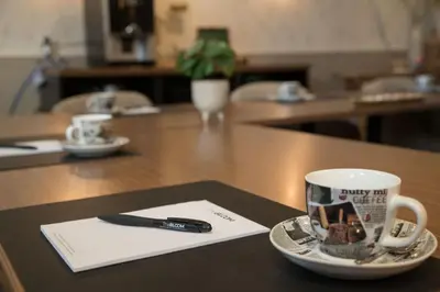 a coffee cup and a pen on a table at The BLOOM in Noordwijk aan Zee
