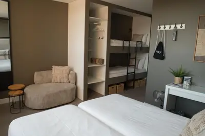 a bedroom with a bed and a couch and a chair at The BLOOM in Noordwijk aan Zee