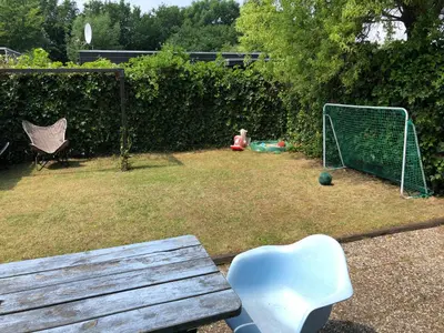 a garden with a bench and a soccer goal at Vakantiehuis Lara in Warmenhuizen