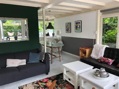 a living room with a couch and a table at Vakantiehuis Lara in Warmenhuizen