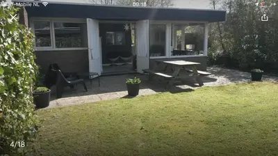 a picnic table and a bench in a yard at Vakantiehuis Lara in Warmenhuizen