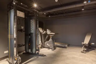 a gym with two treadmills and two chairs at Best Western Plus Amstelveen - Amsterdam in Amstelveen