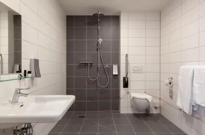 a bathroom with a shower and a sink and a toilet at Best Western Plus Amstelveen - Amsterdam in Amstelveen