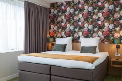 a bedroom with a large bed with a floral wall at Best Western Plus Amstelveen - Amsterdam in Amstelveen
