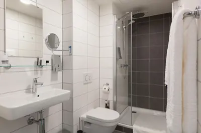 a bathroom with a toilet and a sink and a shower at Best Western Plus Amstelveen - Amsterdam in Amstelveen