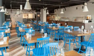 a dining room with blue chairs and wooden tables at Best Western Plus Amstelveen - Amsterdam in Amstelveen
