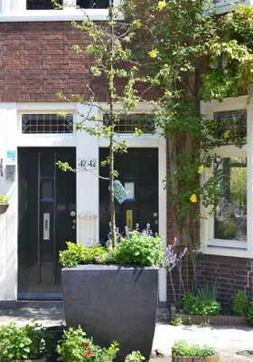 a black front door of a house with flowers at B&B Limes Oudwijk in Utrecht