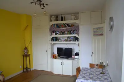 a living room with a table and a tv at B&B Limes Oudwijk in Utrecht