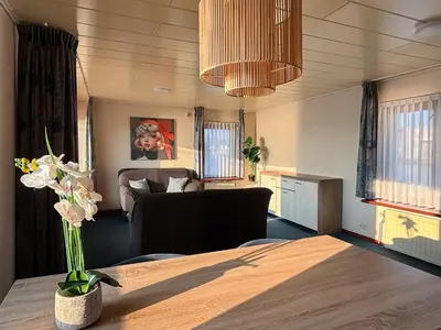 a living room with a table and a couch at VISSERSLUST Rooms, Apartments and Houseboats in Vinkeveen