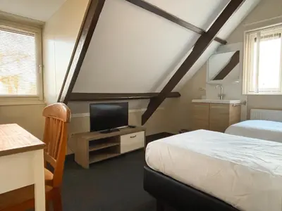 a bedroom with a bed and a tv on a table at VISSERSLUST Rooms, Apartments and Houseboats in Vinkeveen