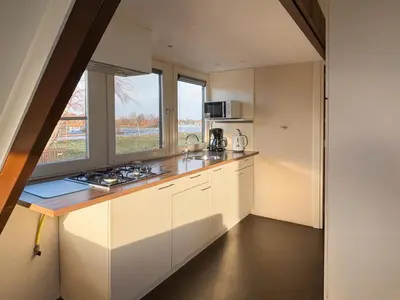 a kitchen with white cabinets and a counter top at VISSERSLUST Rooms, Apartments and Houseboats in Vinkeveen