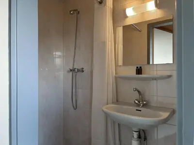 a bathroom with a sink and a shower with a mirror at VISSERSLUST Rooms, Apartments and Houseboats in Vinkeveen