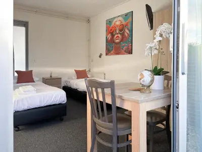 a bedroom with a desk and a bed and a table at VISSERSLUST Rooms, Apartments and Houseboats in Vinkeveen