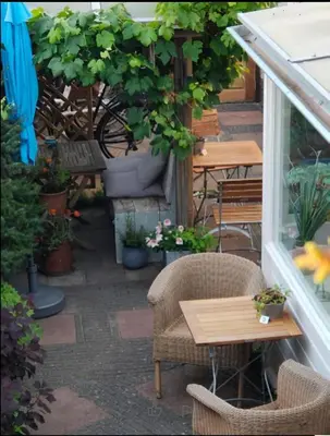 a patio with tables and chairs and potted plants at Zeelui in Egmond aan Zee