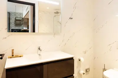 a white bathroom with a sink and a mirror at Boutique Apartments Amsterdam in Amsterdam