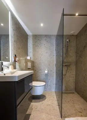 a bathroom with a toilet and a sink and a shower at Hotel Royal in Noordwijk