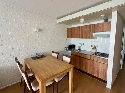 a kitchen with a wooden table and a dining room at Hotel Royal in Noordwijk