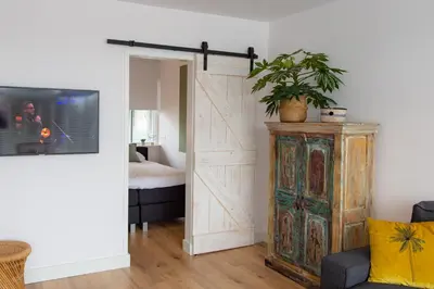 a sliding barn door in a bedroom with a bed at Appartement Zuyd in Zandvoort