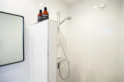 a shower in a bathroom with a mirror at Appartement Zuyd in Zandvoort
