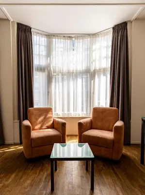 a living room with two chairs and a coffee table at Hotel Residence Le Coin in Amsterdam