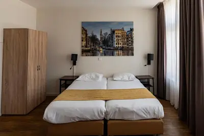 a hotel room with two beds and a painting on the wall at Hotel Residence Le Coin in Amsterdam