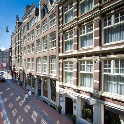 a couple of people walking down a street in front of a building at Hotel Residence Le Coin in Amsterdam