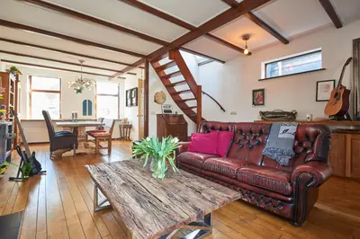a living room with a leather couch and a table at Family home in Edam