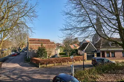 a street in a residential neighborhood with houses and cars at Family home in Edam