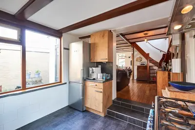 a kitchen with wooden cabinets and a large window at Family home in Edam