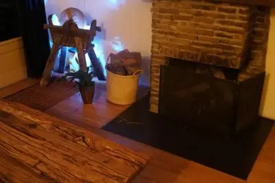 a living room with a fireplace and a wooden floor at Family home in Edam
