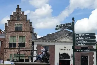 a man sitting on a balcony in front of a building at Family home in Edam