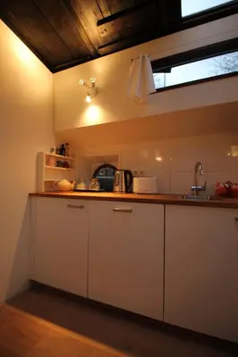 a kitchen with white cabinets and a counter top at Nachtwacht Apartment in Amsterdam