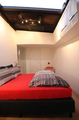 a bedroom with a bed with a red blanket at Nachtwacht Apartment in Amsterdam