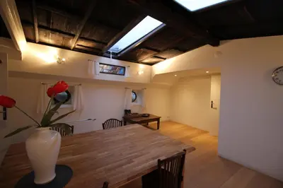 a dining room with a table and a skylight at Nachtwacht Apartment in Amsterdam