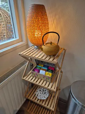 a lamp and a basket on a shelf next to a window at Amsterdam Beach House in Zandvoort